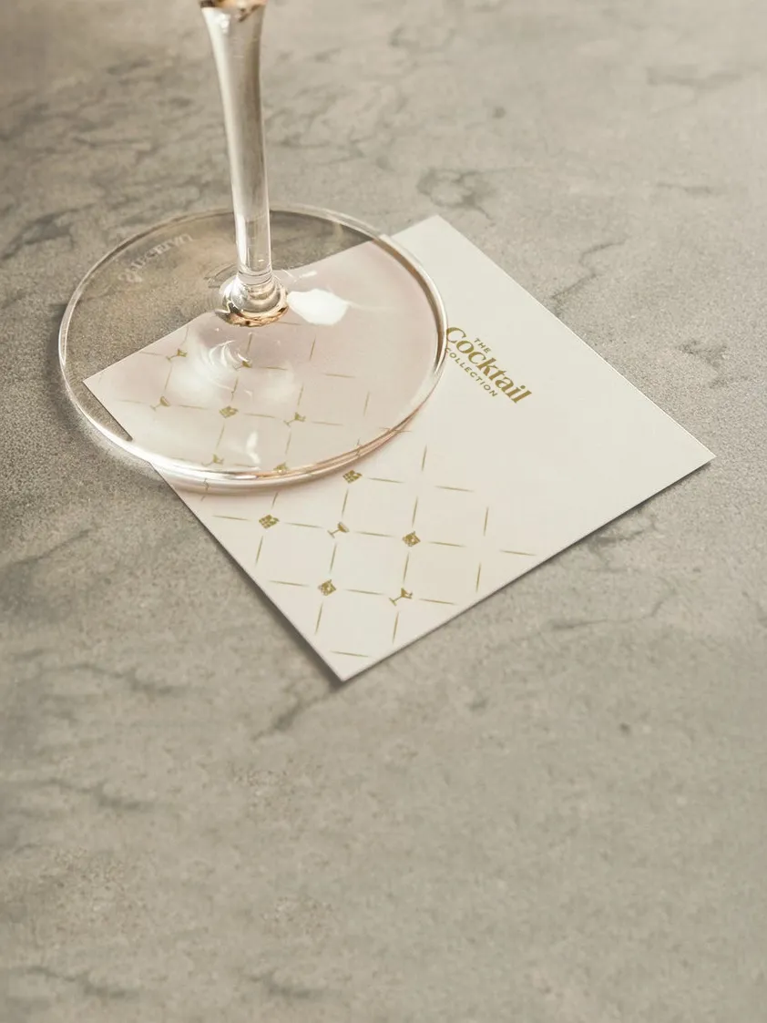 A coupe glass on a Cocktail Collection napkin with the diamond lattice icon pattern
