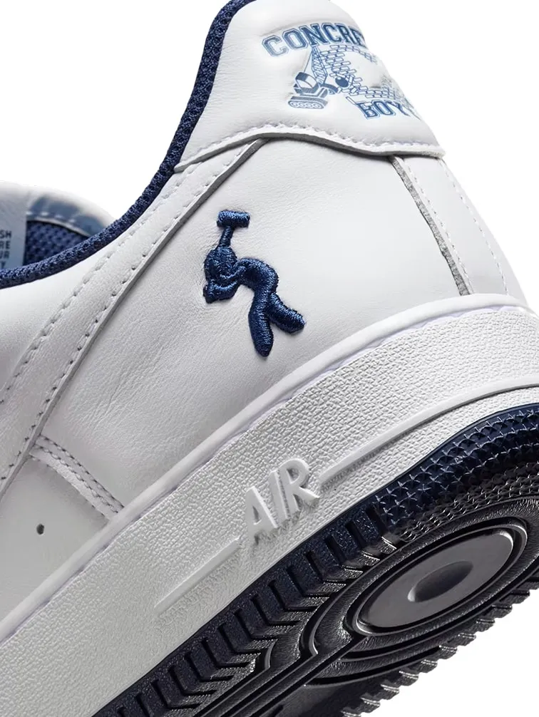 The US Force 1 heel: a white Air Force 1 with a navy embroidered mallet-swinging figure and the Concrete Boys truck mark on the heel tab